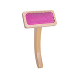 A wooden pet grooming brush with a natural wood handle and frame, featuring a bright pink textured rubber or plastic pad on the head, shown against a plain white background.