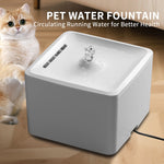 Pet water fountain with a cat sitting next to it on a wooden floor