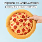 Pizza-shaped pillow with pepperoni slices, held by a hand against a light blue background.