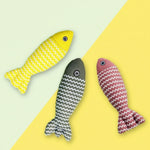 Three fish-shaped cat toys with zigzag patterns on a yellow and green background.