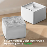 Two white pet water fountains on a wooden floor with text indicating low-voltage and quiet operation.